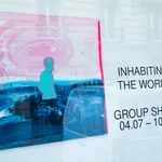 View of AFIKARIS gallery's window featuring Les égarés by Omar Mahfoudi. A work on canvas showing a blue man amidst a water landscape