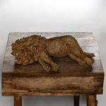 Le Lion allongé, sculpture animalière contemporaine par Bast, lion en position couchée, œuvre expressive de collection en bronze à la surface texturée