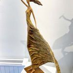 Alizé, een gouden sculptuur van een vrouw, geïnspireerd op Hedwige Leroux: een mooi jong meisje, vrij in de wind in een gouden jurk. Deze hedendaagse bronzen sculptuur is een figuratief kunstwerk en is te zien in de Art Yi-galerie in Brussel.