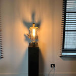 IIXV Visionary XL with light boy sculpture bronze sculpture of Lieven d'Haese garden sculpture boy opening arms to light up a light bulb in his hands with imagination magic dream contemporary art sculpture light interior design at Art Yi gallery in Brussels