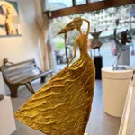 Escultura de Alizé, una mujer dorada que representa a Hedwige Leroux: una hermosa joven libre al viento con un vestido dorado. Escultura figurativa contemporánea en bronce, expuesta en la galería Art Yi de Bruselas.