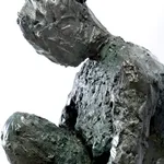 Bronze sculpture of female figure seated on bluestone by artist Emilio DiIorio.