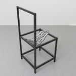 Black wooden chair with a soft sculpture tongue sticking out
