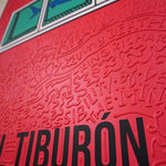 Detail photo of “El Tiburón”, painting by Cayla Birk artist from South Florida. Available at Carousel Fine Art Chicago. The artist’s technique blends traditional acrylic paints with unique materials, creating a distinct mixed media style. Birk's work is marked by intricate designs and recognizable gestures, combining contemporary culture, history, music, and literature. Her art challenges conventional thinking, offering new and unexpected experiences. Colors of this work : Red, Blue, Teal, Beige, White, Black from Florida. Available at Carousel Fine Art Chicago. The artist’s technique blends traditional acrylic paints with unique materials, creating a distinct mixed media style. Birk's work is marked by intricate designs and recognizable gestures, combining contemporary culture, history, music, and literature. Her art challenges conventional thinking, offering new and unexpected experiences. Colors of this work : Red, Blue, Teal, Beige, White, Black