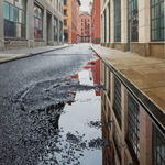 View from ground of puddle on Collister street reflecting grey sky
