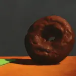 Silver golf trophy on green napkin in swing towards chocolate covered donut