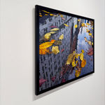 Reflection of city buildings in a puddle with fall leaves in it