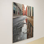 View from ground of puddle on Collister street reflecting grey sky