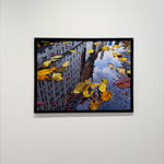 Reflection of city buildings in a puddle with fall leaves in it