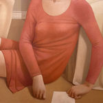 Man in a blue shirt and a woman in a red dress sitting on a bedroom floor