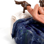 ceramic sculpture of a hand laying in a bed