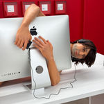 man on a desk hugging his computer