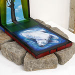 triptych painting positioned on top of a bed of rocks by Mia Scarpa. The artwork represents the tree of life