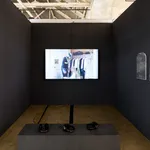 installation image of a video projected against black walls