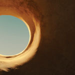 A photograph of a hole in what appears to be a desert rock formation