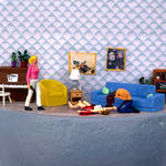 woman standing with a gun next to a bleeding woman on the ground and a kneeling man with his head in his hands