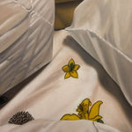 Painting of bed sheets and pillows with a yellow floral design