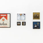 photo of a various paintings hung on a white wall