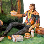 Scenic sculpture of a group of people sitting in a park under palm trees eating in n out on the grass.