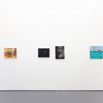 white gallery wall with paintings of various size and colors