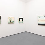 White gallery with four paintings in blue, black, and warm toned colors