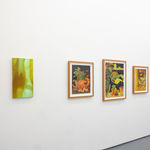 white gallery wall with paintings of various sizes in yellow and green tones