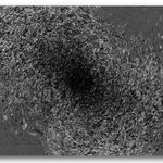 Still from video showing a black hole on a gray background