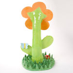 Lorien Stern's ceramic sculpture of an orange flower with grass and bugs