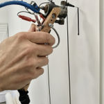 Close up of the artist creating his India ink pieces using his own tattoo-like ink gun