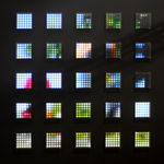 Still image of a spread out grid of twenty five square pieces with multi-colored LEDs behind Plexiglass. The LEDs display pixelated scenes of runners from a marathon