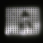 Still image of multiple large hanging white LED strips attached to a long horizontal metal pole The LEDs light the wall behind them with blurred scenes taken from old family home movies