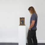 Man admires Untitled (Suited Man Holding Key), installed