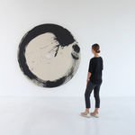 Installation of Enso-afterJuin with woman to the right of the piece to show scale