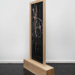 Reverse T-shaped freestanding painting with a wooden frame and base and abstract pink and faded blue crayon marks on a dark background, against a white wall Rindon Johnson Paths wind through woods. Dogs chase their tails. Smiles light up faces. Laughs echo loudly. Dreams take flight. Hopes rise high. Waves roll gently. Children skip merrily. Words convey thoughts. Maroon. Time heals wounds. Minds seek answers. Fates twist and turn. Truths reveal slowly. Lives unfold daily. Manifestation is such a chore. Say it a loud, see it how mouths: a companionable environment can engender impressive thirstiness, 2023 Ash wood, leather, crayon, oil, colored pencil, acrylic and wax 188.5 x 100 x 24.5 cm 74 1/4 x 39 3/8 x 9 5/8 inches