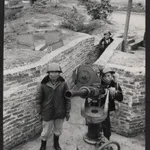 A militia man behind anti-aircraft gun outside a factory in Haiphong. Gun is of American make and factory officials said it had been captured from the French at Dien Bien Phu.