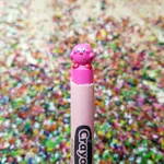 Pink crayon carved into a round smiling cartoon character