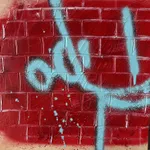 light blue robot outline against a red brick wall