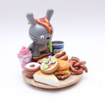 Vinyl Totoro figure with a platter of classic NYC food