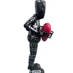 right side view of a black and silver robot statue holding a heart