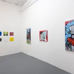 corner of gallery with white walls with a grid of colorful Chris RWK paintings on the left and three larger paintings on the right