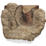 Sculpture featuring a rock and a ripped portrait of a woman surrounded by stone