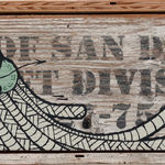 GATS character painted on a white wooden sign with black lettering