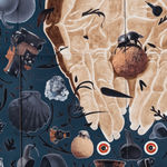 Detail of blue velvet tondo with hands in the middle holding a dung beetle, surrounded by archeological objects