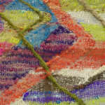A close-up detail of a striped, diagonal composition made from multi-colored fibers stretched across a redwood frame as one would stretch a painting. The fibers are knit at varying thicknesses so that in places one can see through the stitches to the wall behind. The pattern is geometric with two axe-shaped designs rising up from the rest of the picture