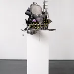 Sculpture with various china, ceramic, kitchen utensils and modified dishwasher on pedestal