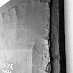 A side-angle macro photograph highlighting the thick, sculptural ridges of the joint compound and the way the light catches the layered chrome and black finish.