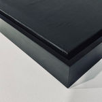 A perspective shot of the bottom corner of the black floater frame, showing the quality of the finish and the depth of the 2 1/2-inch canvas profile.