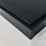 A perspective shot of the bottom corner of the black floater frame, showing the quality of the finish and the depth of the 2 1/2-inch canvas profile.