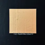 A high-contrast close-up of the textured gold square, revealing raw, tactile ridges and the subtle hand-painted text "THE FUCKING AUDACITY" beneath it.