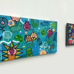 Two cartoon street style art landscape painting hung on gallery wall